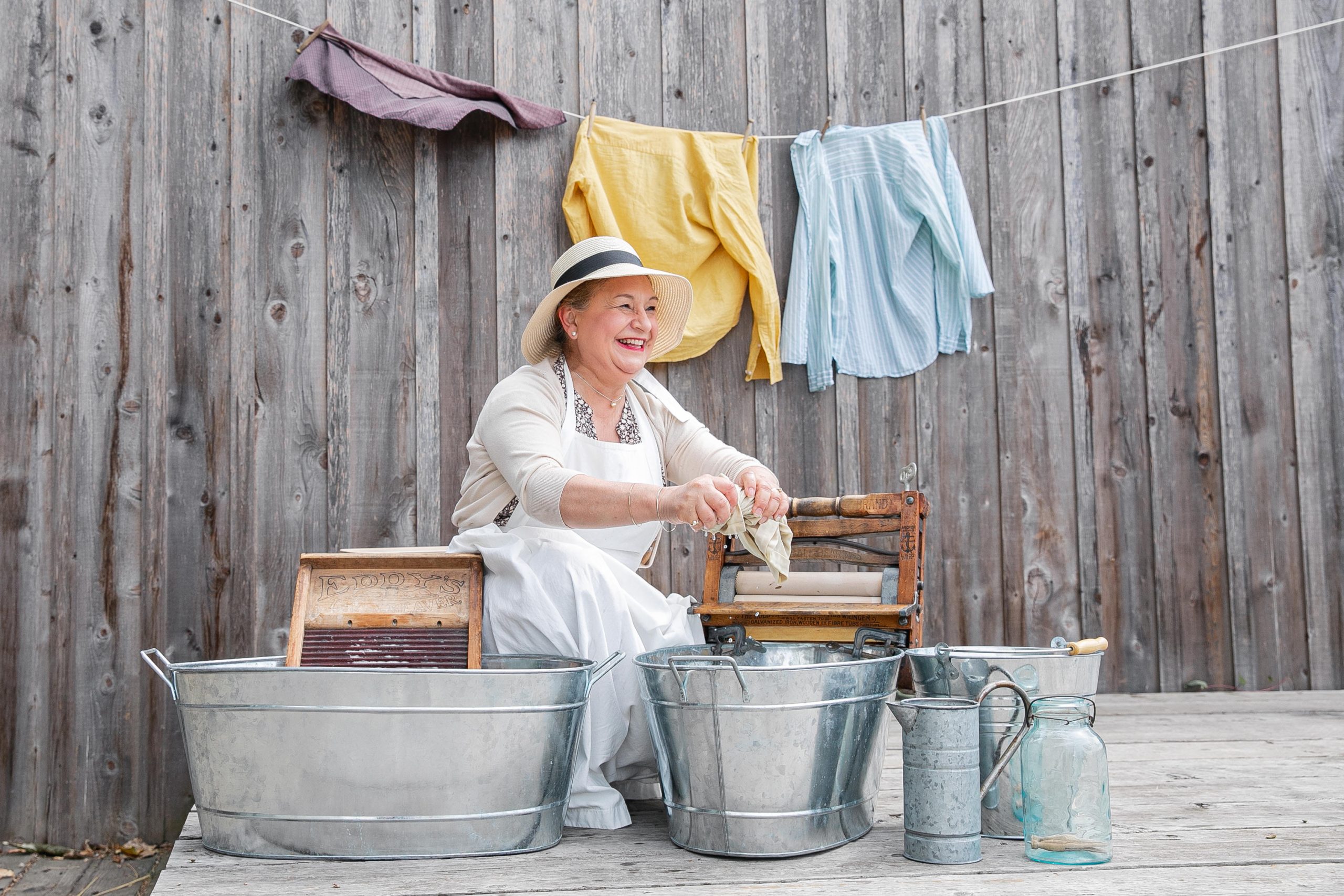Woman in white dress and apron demonstrating handwash laundry