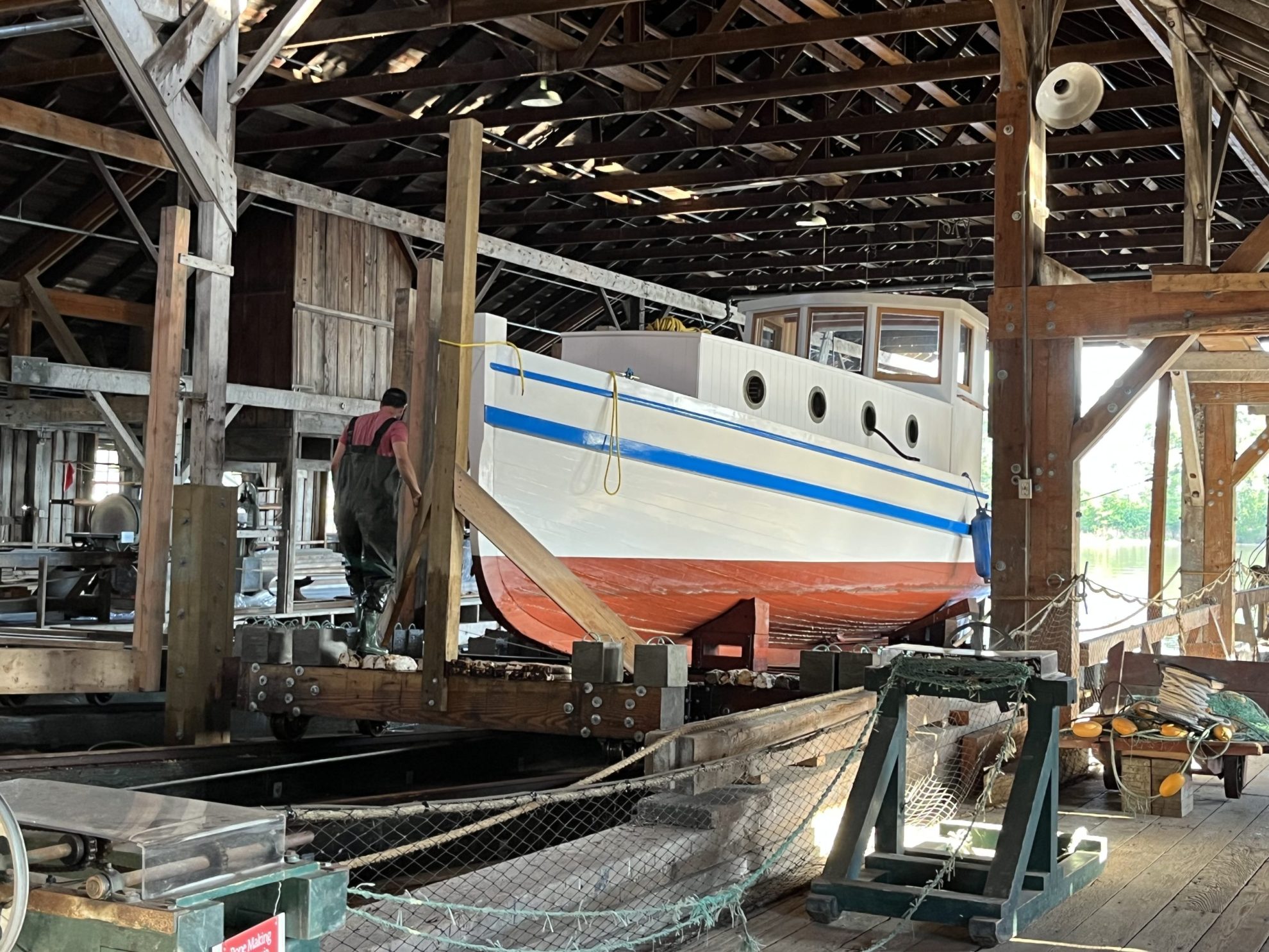 White, red and blue boat, the MV Burnaby on display inside the wooden Britannia Shipyard building