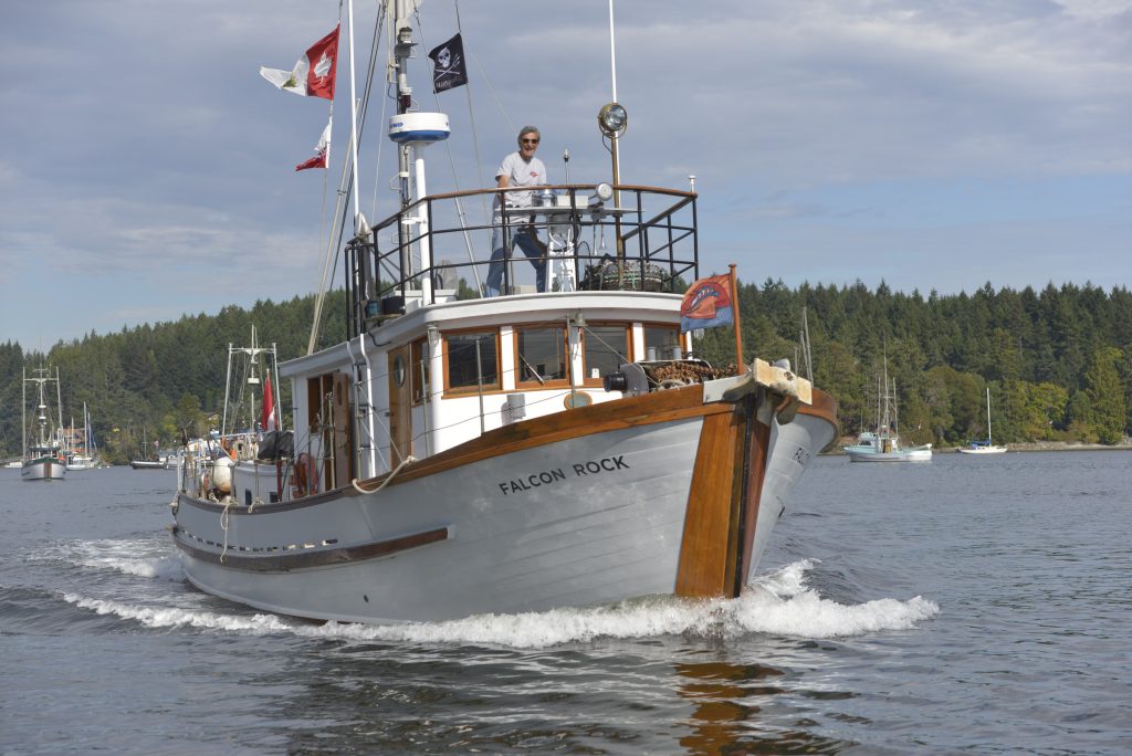 The Falcon Rock (boat with a white and wooden textured hull) sailing on the water.