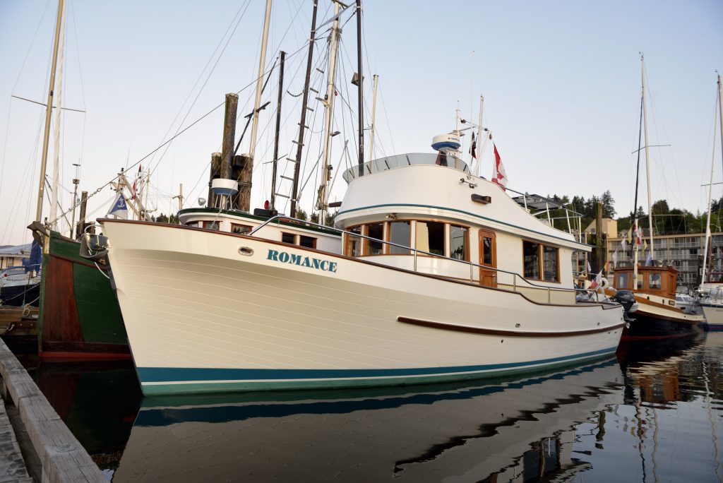 The Romance (boat with a white and blue hull) docked.