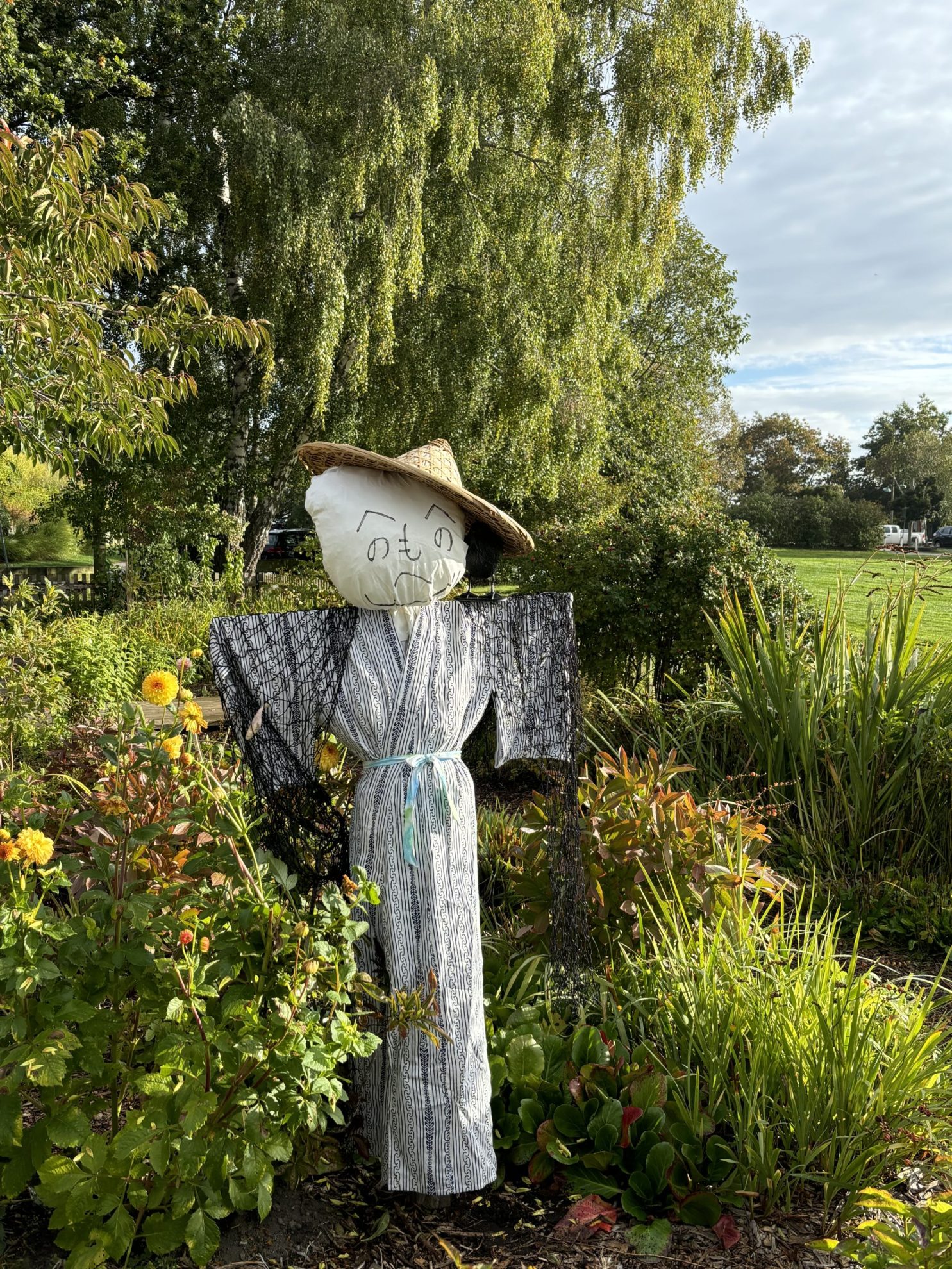 Japanese style kakashi scarecrow on display inside outdoor garden