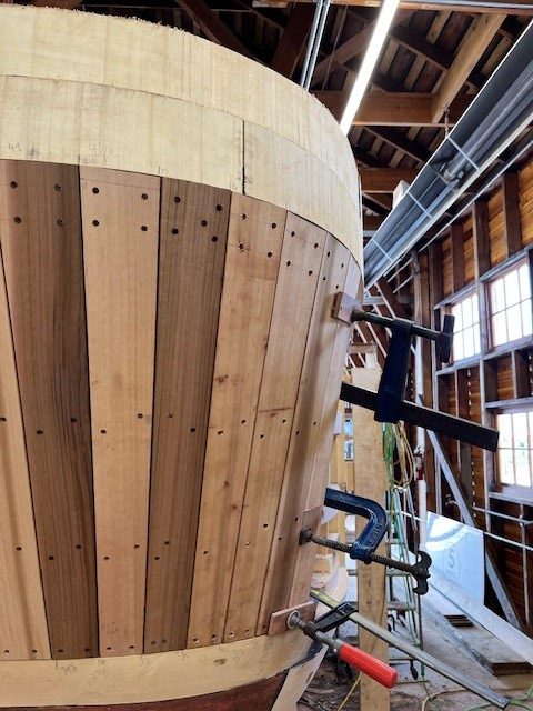 Black vice grips holding wooden planks around the Crystal S boat
