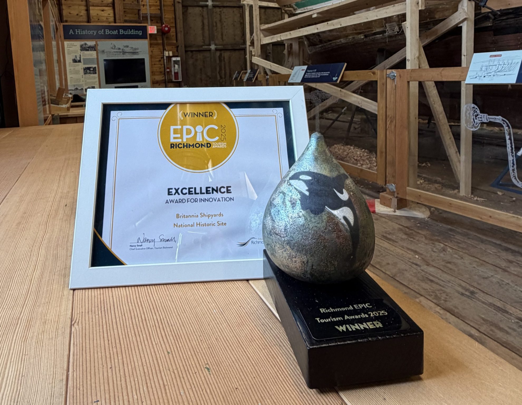 teardrop shaped ceramic trophy with orca design in front of a certificate that says Epic Award