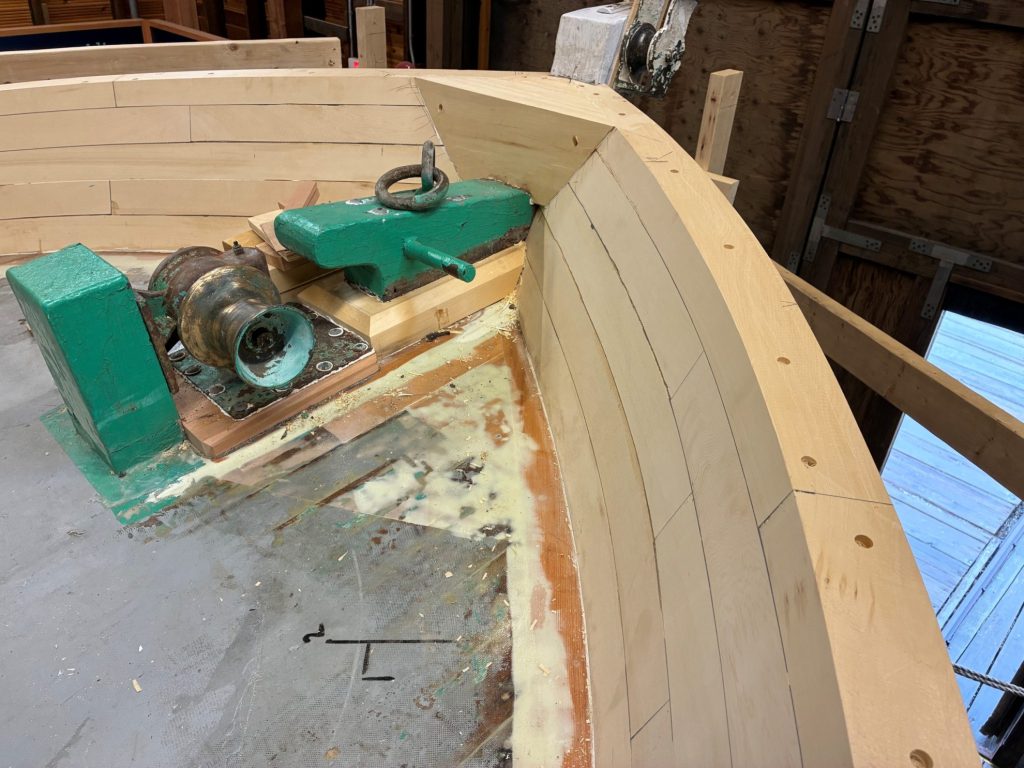 close up of bow of wooden boat with anchor mechanism in place