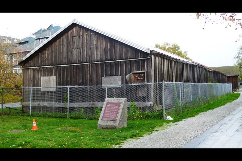 wooden structure behind wire fence and national historic site signage