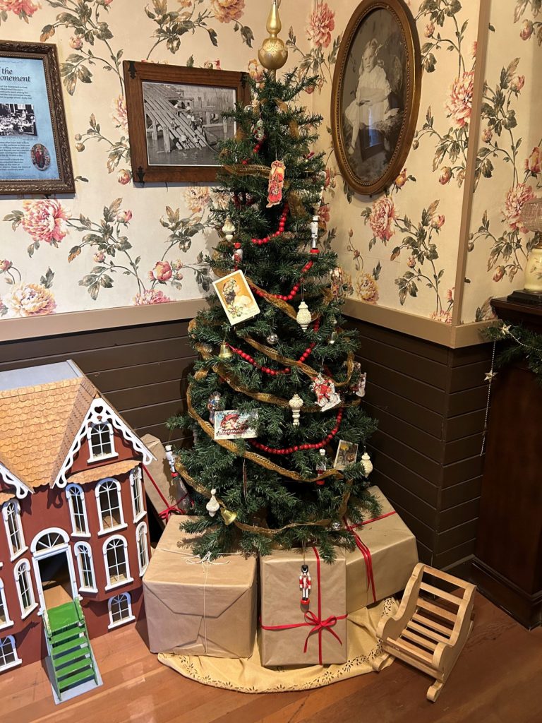 christmas tree and gingerbread house decorations inside a 1920's living room